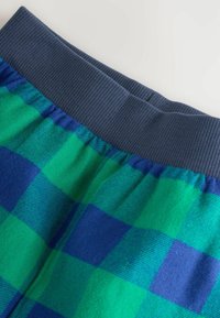 Pantalones de tiro alto con una pretina acanalada de color azul marino oscuro y un patrón de cuadros en tonos verdes y azules sobre una tela suave.