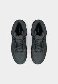 Czarne sneakersy za kostkę z gładką skórzaną cholewką, teksturowaną wyściółką skarpetkową, okrągłymi perforacjami na palcach oraz w tonacji sznurkami.