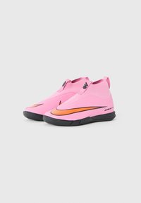 Pink, slip-on athletic shoes with a textured upper, black rubber sole, and an orange accent on the side featuring a swoosh logo.