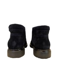 Bottines en daim noir avec un bout rond, des semelles texturées et des coutures bleues contrastantes. Hauteur environ au milieu du mollet.