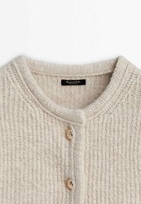Beige gebreide cardigan met een ribbelstructuur, ronde halslijn en drie gouden knopen aan de voorkant. Label zegt "Massimo Dutti."