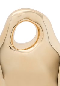 Guldfarvet skulpturelt objekt med en glat, reflekterende overflade. Har en oval udskæring på toppen og en buet, organisk form.