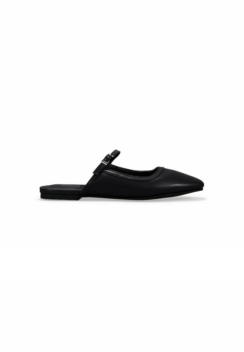 Zapatos planos de cuero negro con tirante al tobillo, de punta afilada, con una tira delgada en el tobillo y una textura suave y mate. Diseño minimalista.