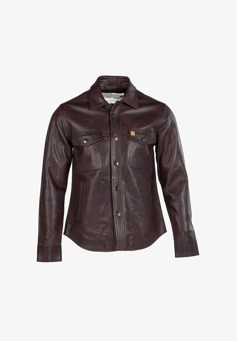 Barna bőrdzseki gombos elülső résszel, két mellzsebbel és hegyes gallérral. Sima textúra és enyhén testhezálló sziluett.