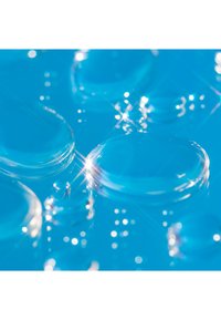 Gotas de agua redondas y transparentes sobre una superficie azul brillante, reflejando la luz y creando suaves brillos. Textura suave con tamaños variables.