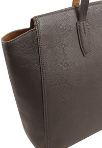 Donkergrijze leren tote met een gestructureerd ontwerp, gladde textuur en subtiele stikdetails. Beschikt over twee stevige handvaten voor het dragen.