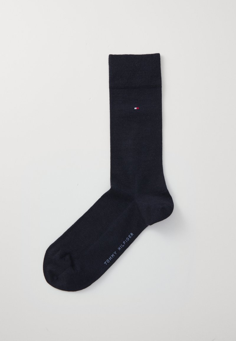 Navy cotton sock with a ribbed cuff, featuring a small red, white, and blue logo and "TOMMY HILFIGER" printed along the side.