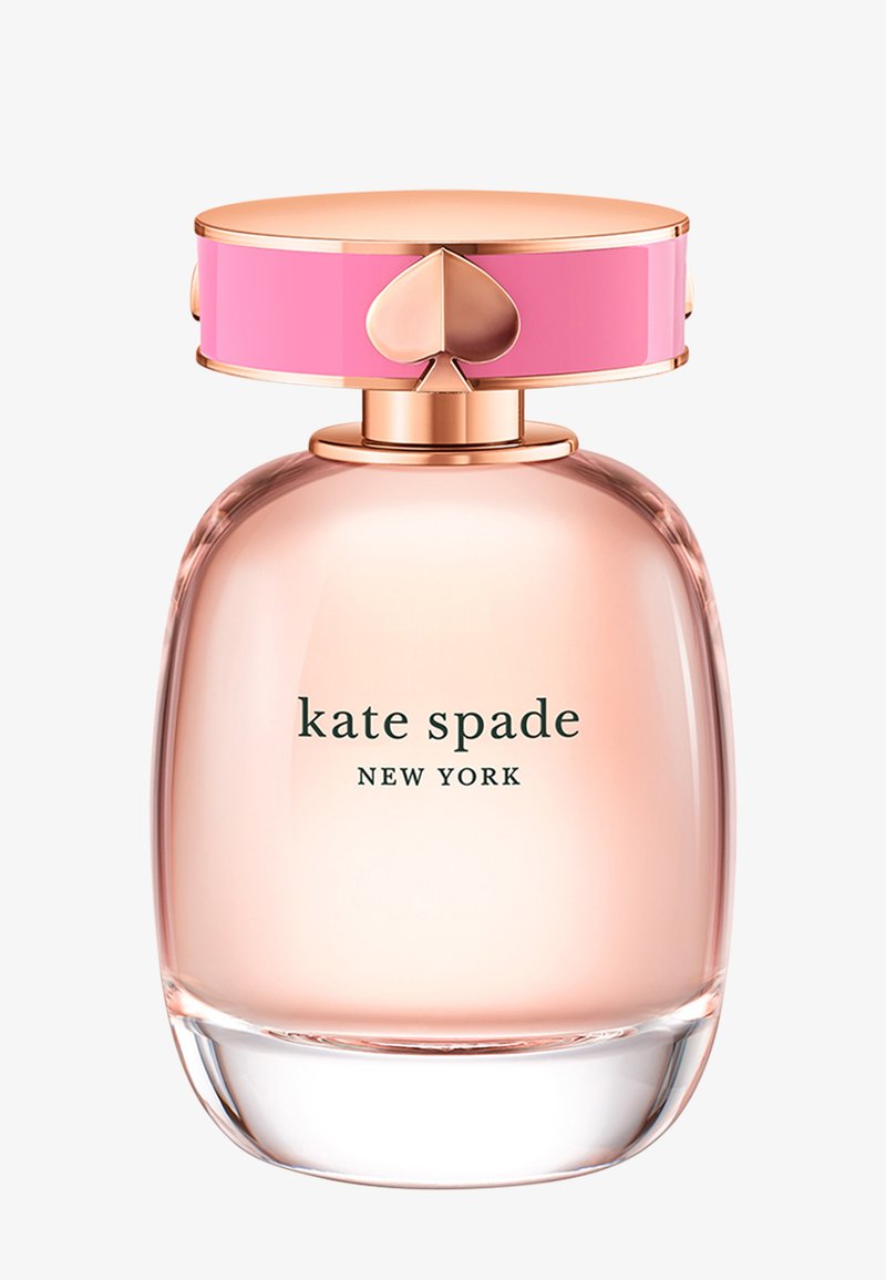 Przezroczysta szklana butelka perfum z różową i złotą nakrętką z motywem serca. Płyn w środku ma jasnoróżowy kolor. Etykieta brzmi "kate spade NEW YORK."