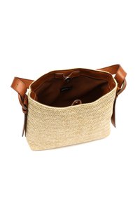Beige vävd stråväska med brun läderaxelrem, stängning med knapp på toppen och brunt fodrat inre med ett varumärke.