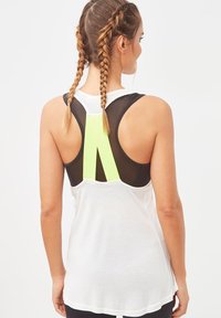 Top sin mangas blanco con un panel trasero de malla negra que presenta un acento en verde neón. El material parece ligero, adecuado para ropa deportiva.