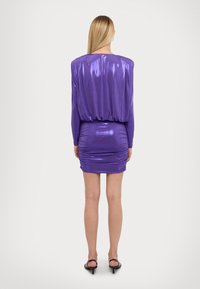 Fialové metalické šaty s dlouhými rukávy, nařaseným pásem a mini délkou. Mají mírně řasený zadní design.