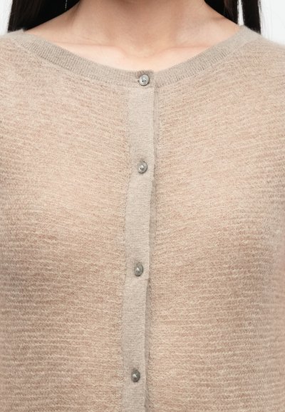 Beige Strickjacke aus weichem, strukturiertem Garn mit rundem Ausschnitt und fünf Metallknöpfen auf der Vorderseite.