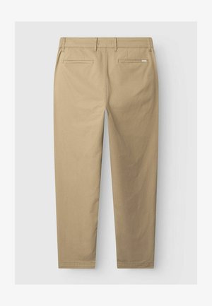 Bēša taisna silueta bikses ar jostas cilpām un divām aizmugurējām ieliktajām kabatām, redzamas no aizmugures uz vienkārša fona.