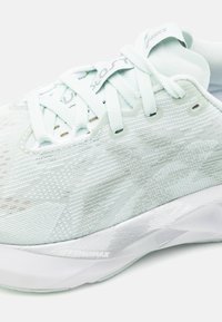 Chaussure de sport vert clair avec une tige texturée et une semelle blanche. Les caractéristiques comprennent un système de laçage et un logo "FF BlastMAX" sur le côté.