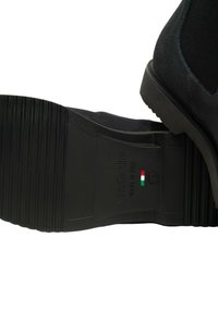 Suola nera di una scarpa da uomo che mostra il marchio NeroGiardini, il testo "Made in Italy", la bandiera italiana e la marcatura di taglia 42.
