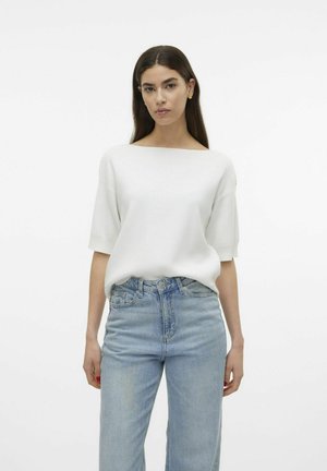 Haut en tricot blanc à manches courtes avec un décolleté bateau. Associé à un jean en denim bleu clair taille haute. Design simple, sans motifs ni accents.