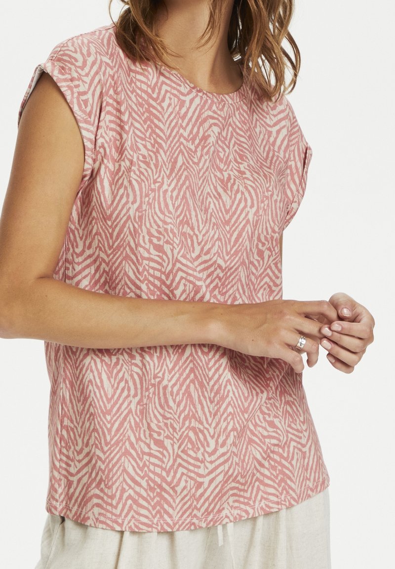Růžový top s krátkým rukávem se strukturou vlnového bílého vzoru. Kulatý výstřih, volný střih a měkká tkanina s jemným leskem.