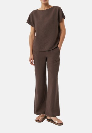 Brown crepe top with short sleeves, paired with matching wide-leg pants, and flat sandals featuring gold accents. Smooth, textured fabric.