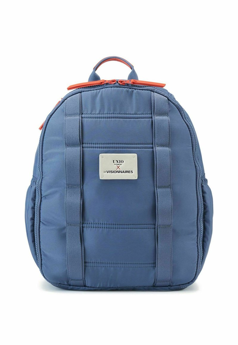 Mochila azul acolchada con cremalleras naranjas, asas laterales y una placa de metal decorativa con acentos de costura. Textura de tela duradera.