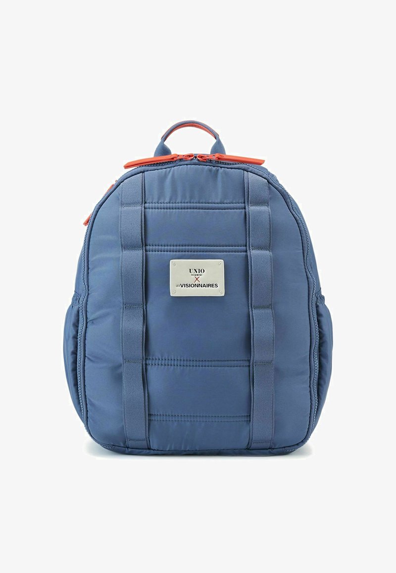 Zaino imbottito blu con zip arancioni, manici laterali e una piastra in metallo decorativa con dettagli ricamati. Tessuto resistente.