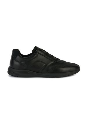 Zapatilla negra de piel con una textura suave, punta redondeada, cordones elásticos y suela acolchada. Los detalles en el panel lateral crean sutiles acentos de diseño.
