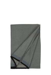 Couverture grise à motif en chevrons avec une texture douce. Les bords présentent des accents à franges noires. Le revers est d'un gris clair uni.