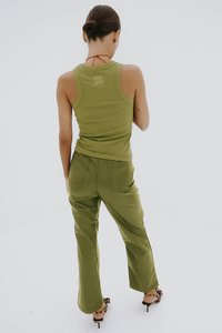 Olijfgroene tanktop en bijpassende broek van een gladde, rekbare stof. De broek heeft twee achterzakken en een uitlopende pijpdesign.