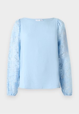 Ανοιχτό μπλε μπλούζα με μακριά μανίκια από διάφανη δαντέλα με λουλούδια και στρογγυλή λαιμόκοψη.