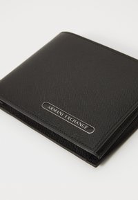 Portofel pliabil negru cu o suprafață texturată. Îndeplinește un plăcuță metalică cu logo-ul "Armani Exchange" pe față. Design compact, material durabil.