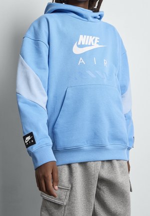 Sudadera Nike de color azul claro con un bolsillo frontal, logo Nike blanco y etiqueta negra en la manga. Presenta mangas azules en contraste y puños acanalados.