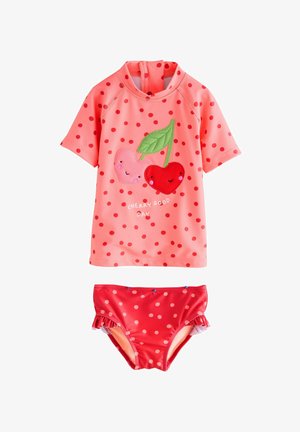 Set de rash guard cu mâneci scurte, de culoare roz, decorat cu puncte roșii și aplicații în formă de cireșe. Chiloți bikini asortați, cu puncte roșii.