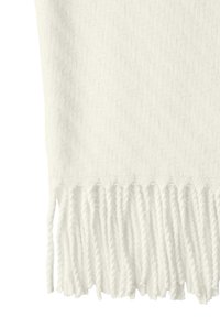 Couverture blanche tissée avec un motif en chevron et des franges le long du bord, fabriquée en matériau doux et moelleux.