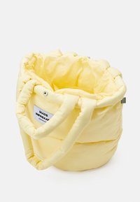 Gele gewatteerde tote bag met een getrokken bovenkant, twee stevige handvatten en een klein logo-label aan de zijkant, met een gladde, zachte textuur.