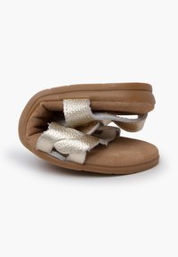 Gold metallic woven straps over a soft, tan suede footbed; flexible rubber sole; compact design with rounded edges and slight heel.