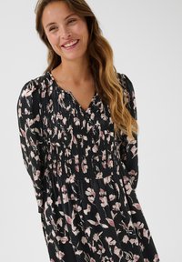 Rochie lungă cu mâneci lungi, de culoare neagră, cu textură strânsă, având un model floral cu flori roz și albe, decupaj în formă de V și croi lejer.
