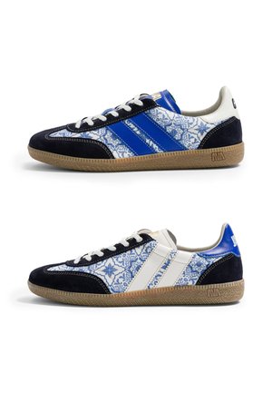 Paire de baskets basses avec motifs complexes bleu et blanc rappelant des carreaux, accents en daim noir, semelles en gomme et bandes latérales contrastées.