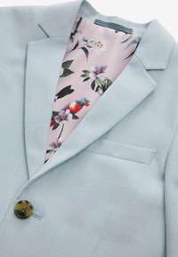 Blazer azzurro chiaro con una finitura testurizzata, caratterizzato da una fodera fiorata rosa e un dettaglio con un singolo bottone rotondo.