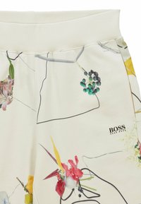 Sweatpants i mjukt vitt tyg med färgglada blommönster och abstrakta svarta konturer, med elastisk midja och logodetalj.