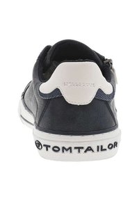 Sneaker en cuir bleu marine foncé avec un talon rembourré blanc, un motif texturé sur le côté et une semelle en caoutchouc blanc avec des lettres de marque.