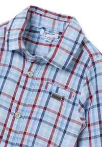 Camisa a cuadros azul y blanca con acentos en rojo y marino, cuello abotonado, bolsillo frontal y etiqueta de metal con logotipo cerca del bolsillo.