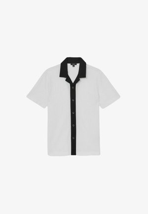 Rövid ujjú ing fehér bordázott anyagból, fekete gallérral és gombos elülső résszel. Minimalista dizájn, kontrasztos színekkel.