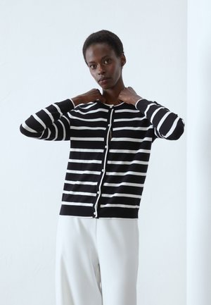 Cardigan rayé noir et blanc avec un col rond et une fermeture à boutons à l'avant. Matière douce, manches longues et légère nervure à l'ourlet.