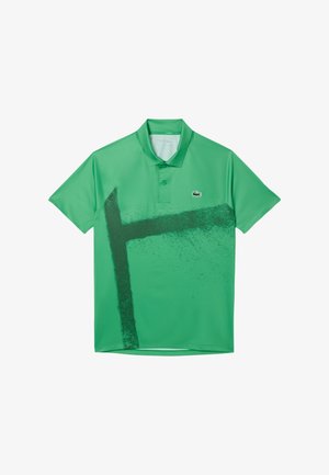 Camisa polo verde hecha de una tela suave con un diseño gráfico negro audaz. Incluye un cuello, dos botones y un pequeño logo en el pecho.
