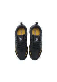 Scarpe da ginnastica nere con dettagli gialli, design con lacci, collare imbottito e logo sulla linguetta. Materiale liscio con suola texturizzata.
