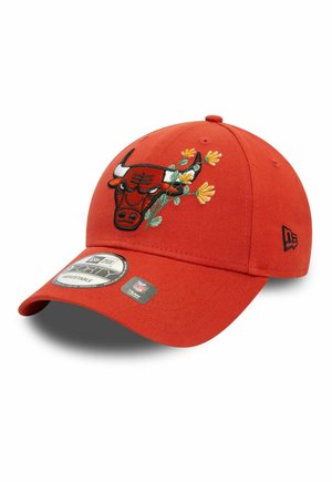 Rote verstellbare Baseballkappe mit einem schwarz-weißen Stier-Logo und gelb bestickten Blumen auf der Vorderseite, mit sichtbaren NFL- und New Era-Markenetiketten.