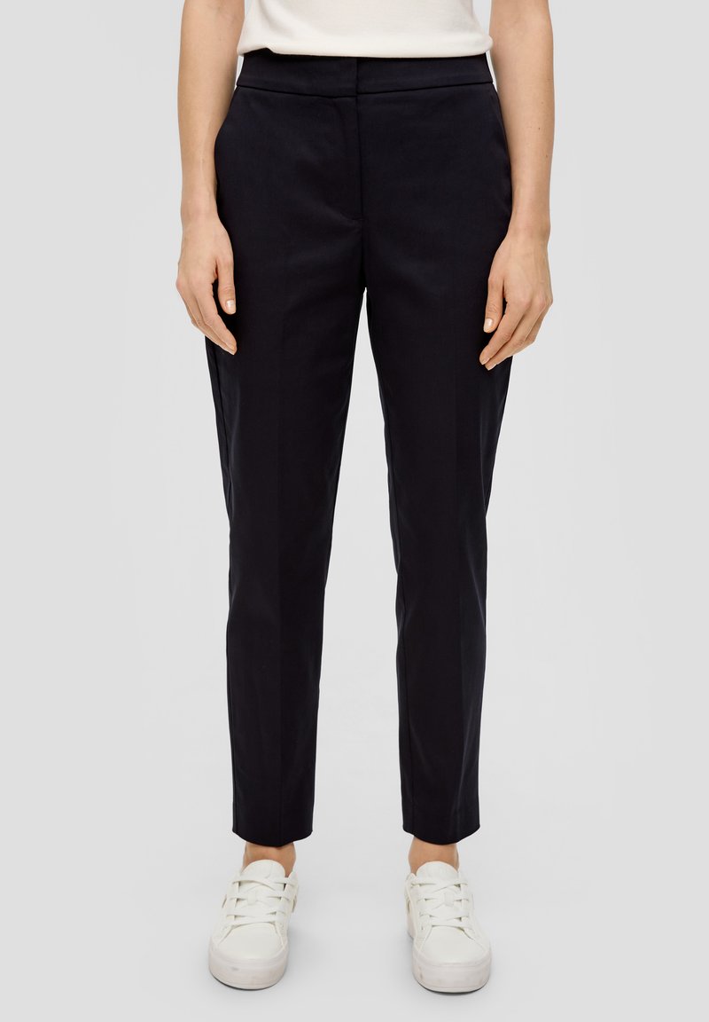 Marineblauwe op maat gemaakte broek van een gladde stof, met een slim fit, riemlussen en zijzakken. Gemaakt met witte sneakers.