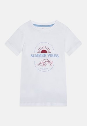 T-shirt en coton blanc avec un graphisme "SUMMER VIBES" en rouge et bleu, agrémenté d'un motif soleil et vague. Manches courtes et col rond.