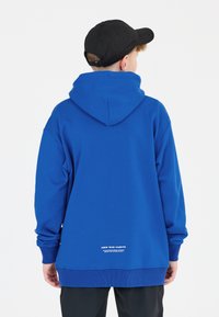 Sweatshirt à capuche bleu avec une poche kangourou, des poignets et un ourlet côtelés, présentant un logo et un détail textuel dans le bas du dos.