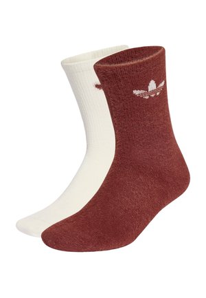 Keskipitkät sukat, toinen kokonaan valkoinen ja toinen ruosteenvärinen ruskea, jossa pieni valkoinen Adidas-trefoil-logo varren lähellä.