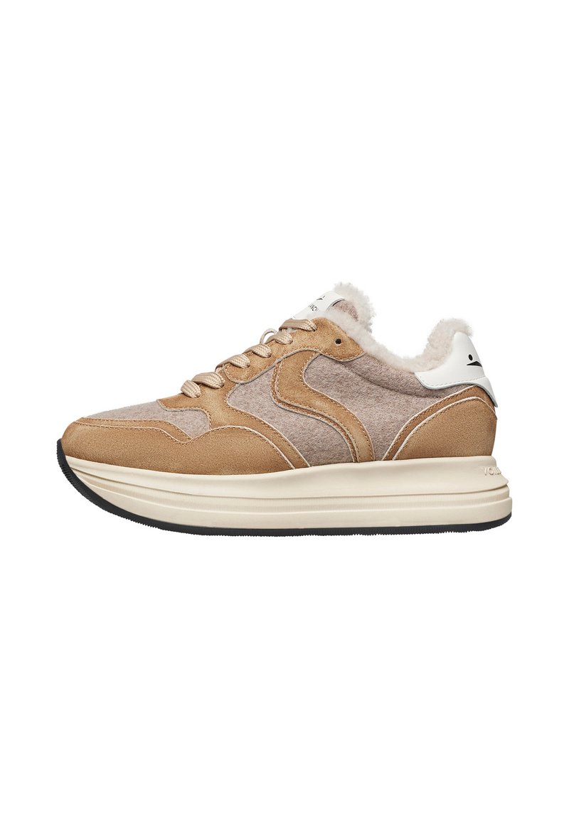 Sneaker beige e marrone con materiali in suede e feltro, tomaia testurizzata, un accento bianco sul tallone e una suola intermedia spessa color crema su una suola nera.